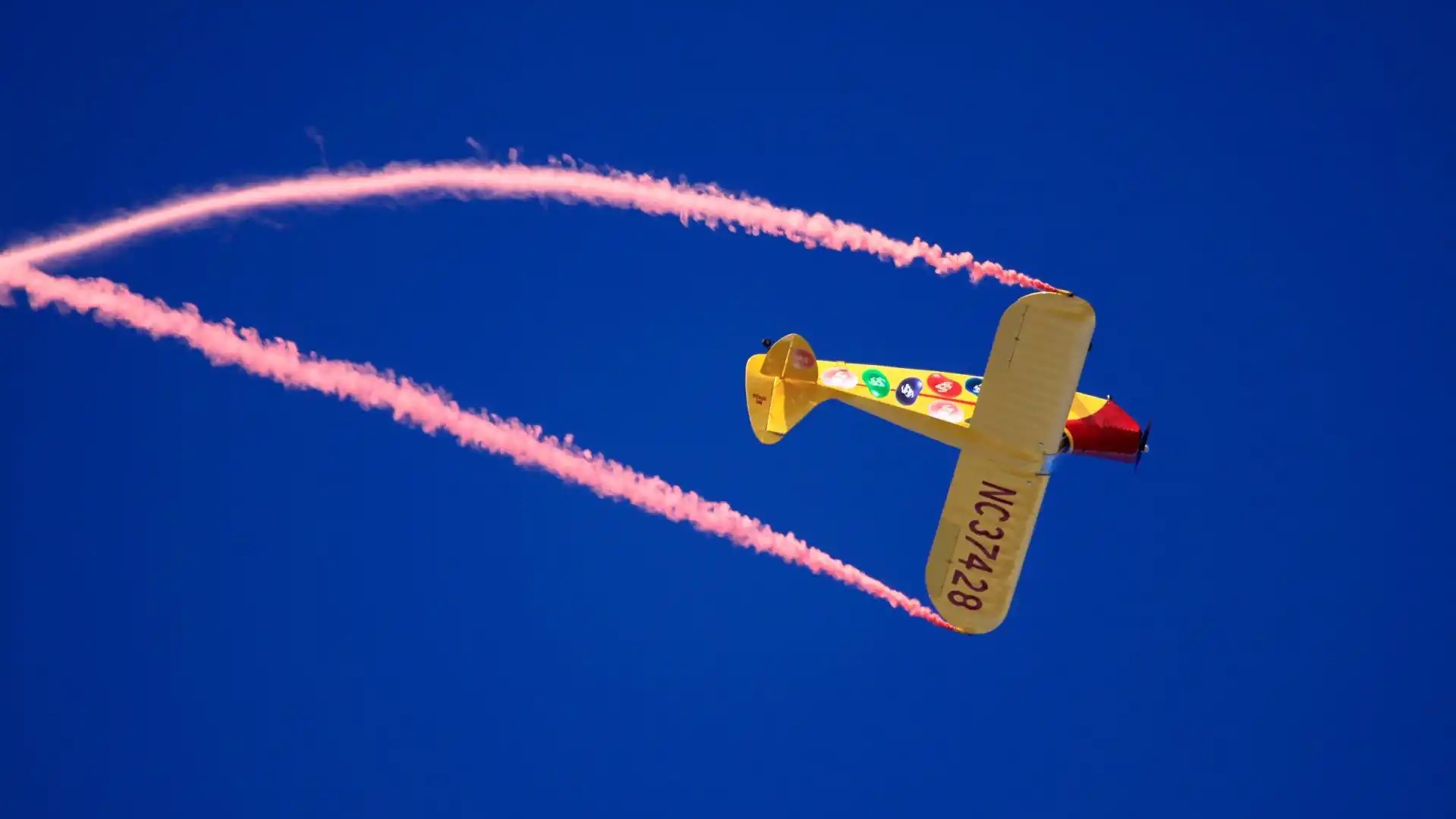 Jelly Belly Aircraft performing barrel roll with smoke